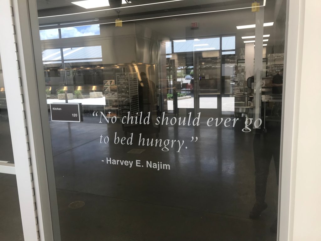 Glass door with inspirational quote by Harvey E. Najim.