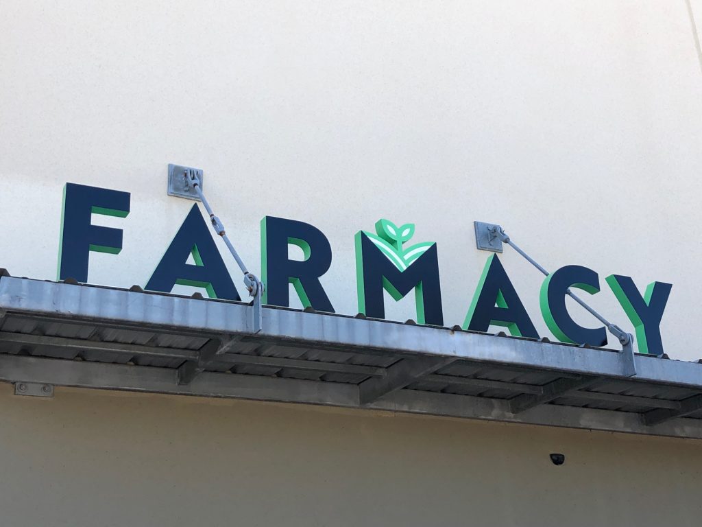 Farmacy sign with green leaf design