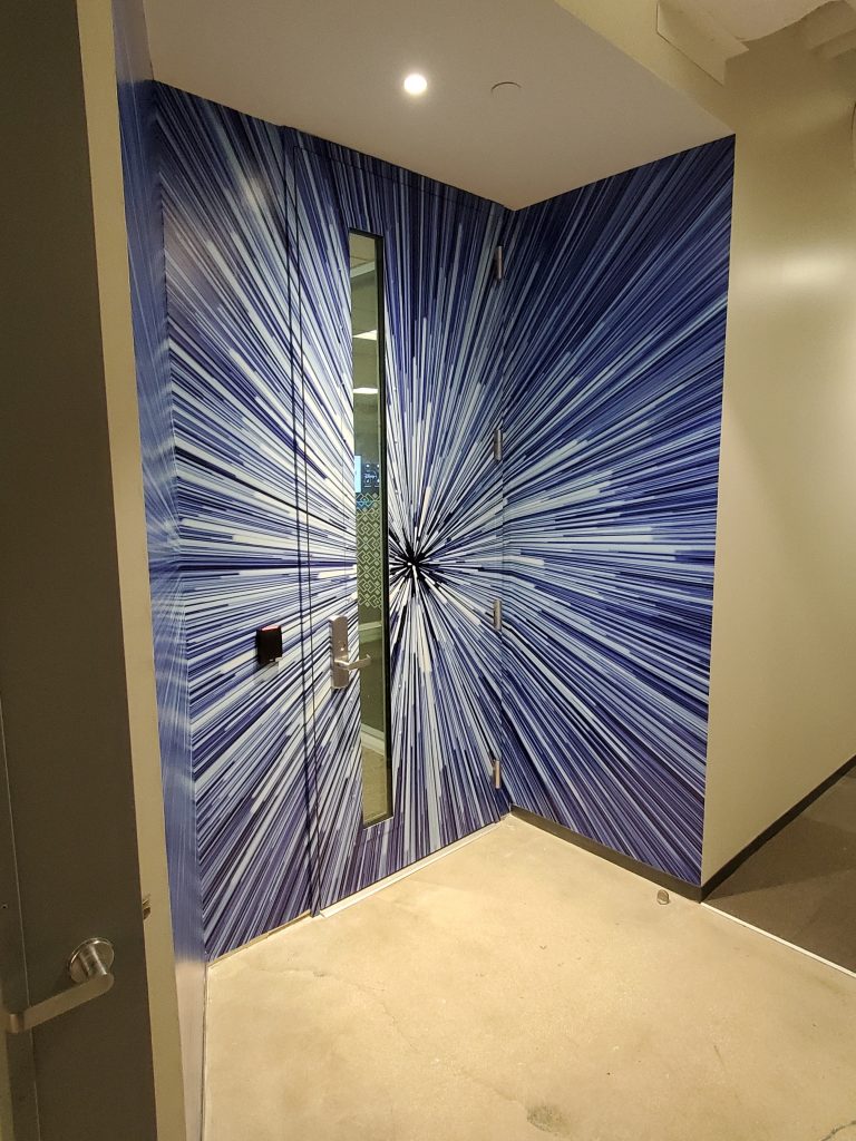 Starburst-patterned door in modern hallway.