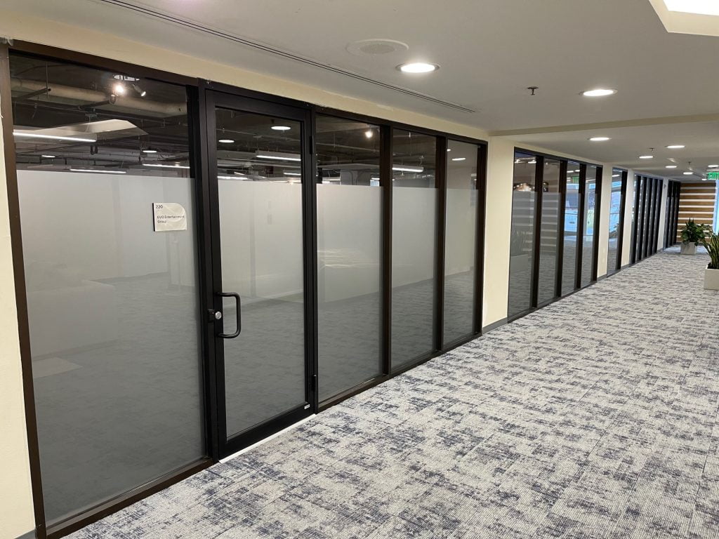 Office corridor with glass-walled rooms.